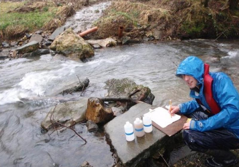 APEM staff member taking water samples
